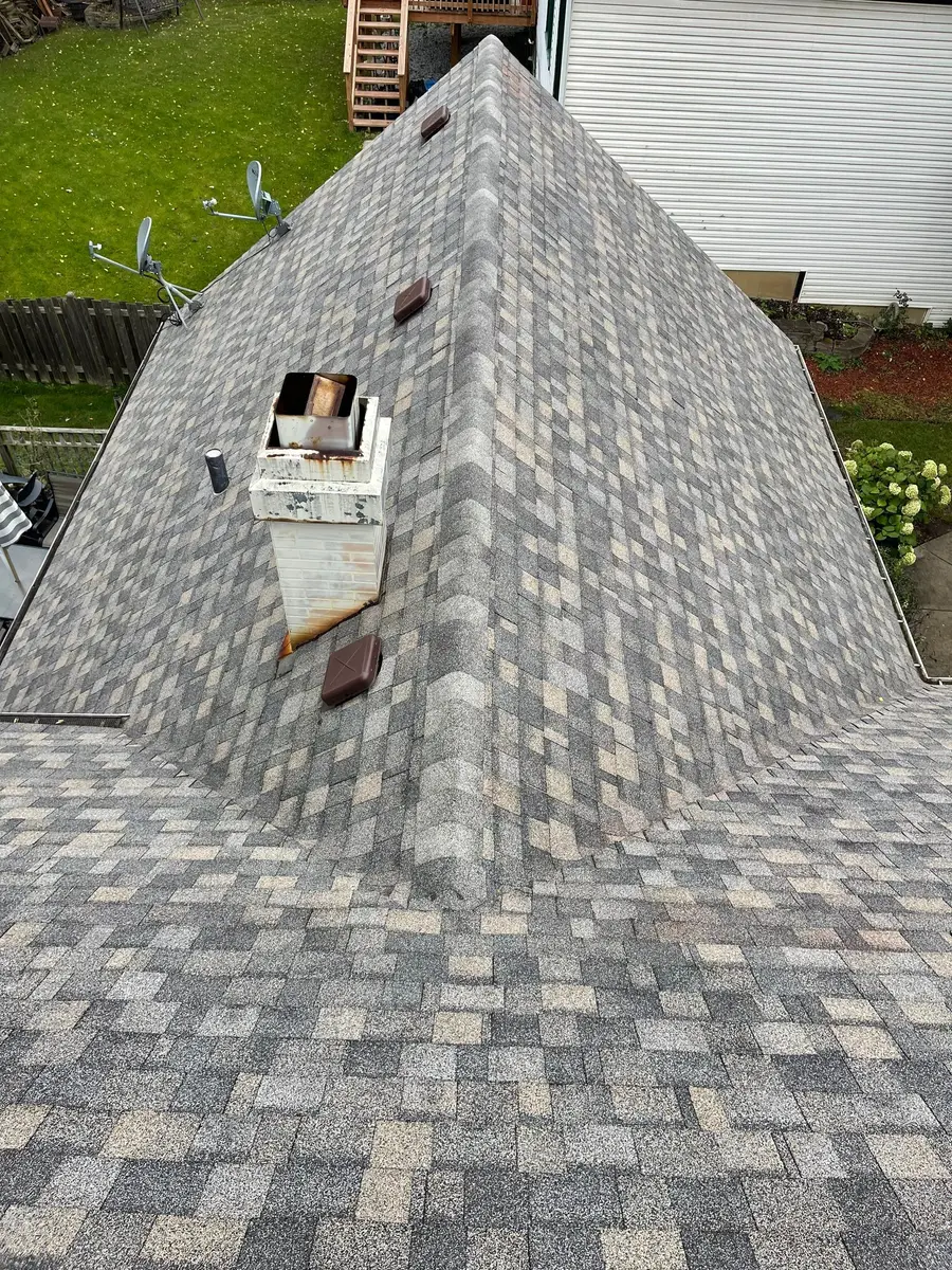 Chimney chase and two box vents on a newly shingled hip roof